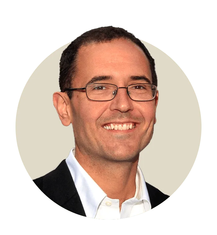 headshot of Geoff Cook, Chief Executive Officer of Noom, framed in a circular coral background. Represents Noom’s executive leadership and strategic vision.